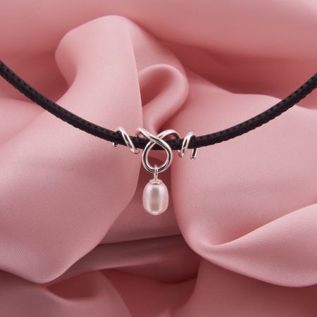 Schwarze Lederkette Remolino mit gewickeltem 925 Sterling Silber Anhänger und einer frei schwingenden, weißen Süßwasserzuchtperle.